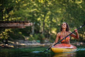 Paddling young female on the river