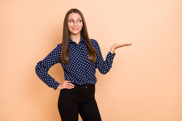 Photo of young woman happy positive smile show hand product promo offer suggest isolated over beige color background