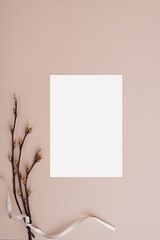Greeting card, invitation, wedding stationery mockup, spring twigs with white ribbon, vertical, top view.