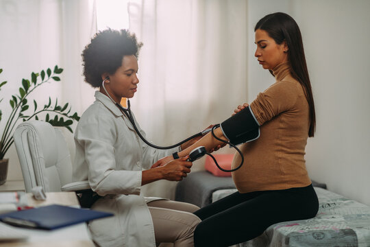 Doctor measuring blood pressure to pregnant woman