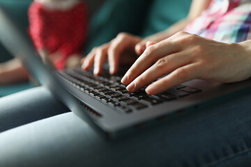 Female hands are typing on laptop keyboard