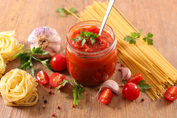 tomato sauce and pasta on wood background