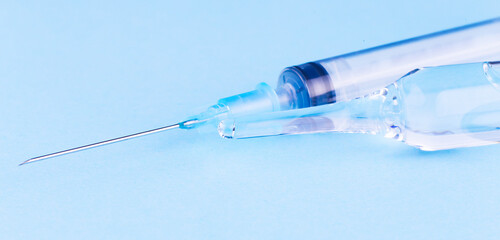 Syringe and ampoule on blue background ,medical concept