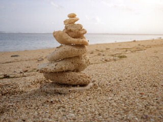 Fototapeta na wymiar Zen stones stacked on a sandy tropical beach.