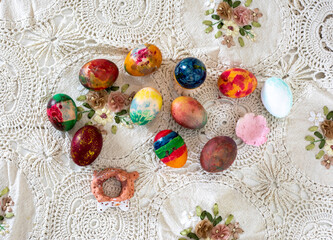 Fototapeta na wymiar easter colorful eggs on vintage tablecloth, easter preparation for the holiday top view