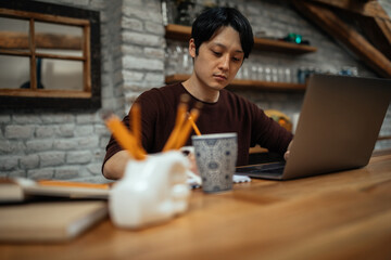 Asian man working at home. typing on computer.