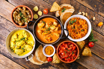 assorted indian food - naan, curry chicken, dhal lentil and rice
