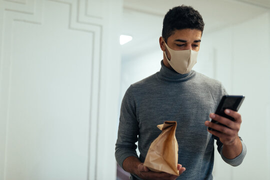 Man with face mask delivering food. Home food delivery during lockdown