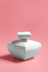 White ceramic bottles on a pink background.