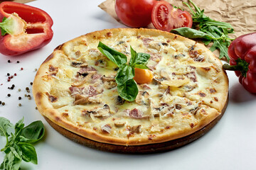 Classic Italian pizza carbonara with yolk, bacon, parmesan, mushrooms and white sauce on a plate. White background. Italian Cuisine. Selective focus