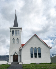 Small Icelandic christian church with a dramatic sky in the background. Northern architecture.