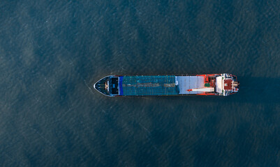 Photo aérienne panoramique ultra large par drone d'un porte-conteneurs industriel naviguant en pleine mer dans le bleu profond de l'océan - obrazy, fototapety, plakaty