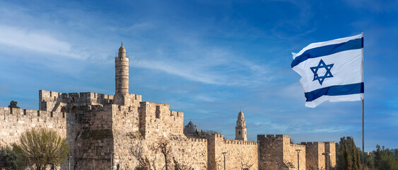 Fototapeta premium Panorama of Jerusalem Citadel near the Jaffa Gate with Tower of David, ancient fortress walls and Israeli flag