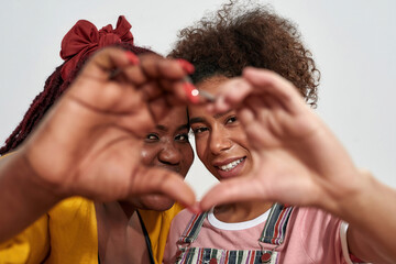 Picture of a two black women making a heart with hands and smiling from inside
