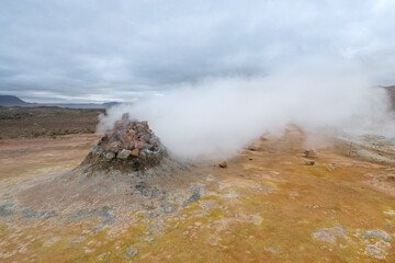 Steam rising from boling mud in the Icelandic landscape.