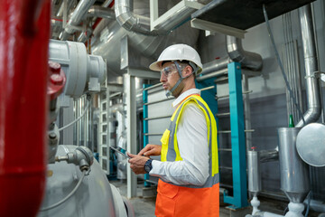 Engineer checking the valve equipment in a boiler at control room of a modern thermal power plant at large industry factory.