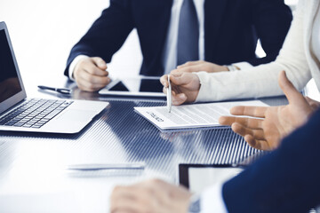 Business people discussing contract working together at meeting in modern office. Unknown businessman and woman with colleagues or lawyers at negotiation