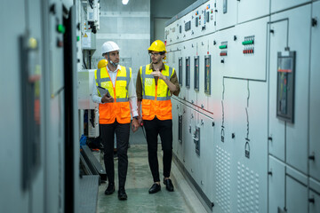 Technical worker with engineer working and checking in control room power plant at industry factory.
