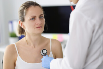 Obraz premium Patient listens to patient lungs through stethoscope