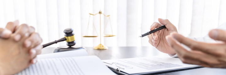 Fototapeta premium Lawyer preparing to sign a contract and wooden gavel on table justice and law concept.