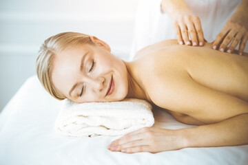 Obraz na płótnie Canvas Happy woman enjoying back massage with closed eyes. Beauty and Spa salon concept