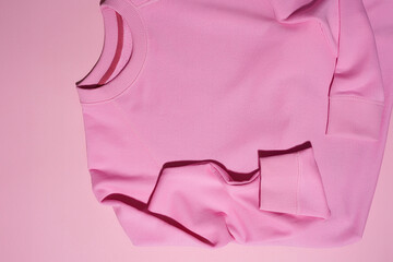 Top view of pale pink pastel sport blank sweatshirt isolated on pink background