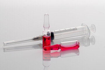 Ampoules with a medicine and a syringe on a light background. Coronavirus vaccine. Medical concept. Isolate.