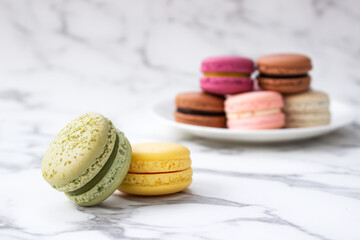 Homemade colorful macaroons on marble background. French dessert.