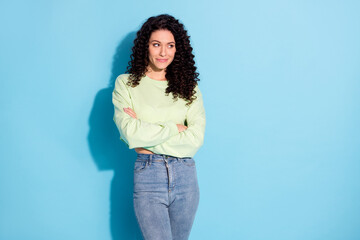 Photo of confident cute lady crossed hands look empty space wear sweater jeans isolated blue background