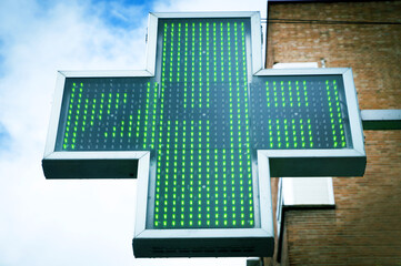 Green pharmacy cross indicating 24 hours of opening