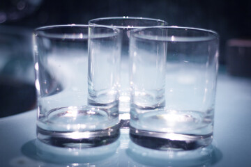 Three empty crystal glasses on dark background