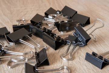 Black paper clips on wood table