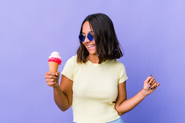 Young mixed race woman eating an ice cream dancing and having fun.