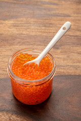 Tasty sea food, red trout fish caviar in glass jar