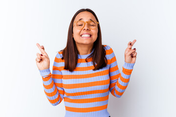 Young mixed race woman isolated crossing fingers for having luck