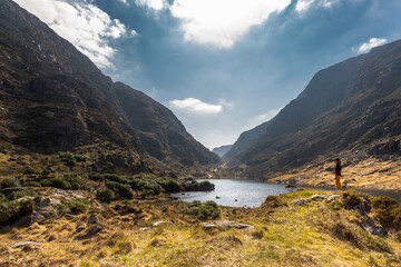 female cyclist admiring mountainous scenery at Gap of Dunloe kerry mountains