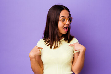 Young mixed race woman isolated surprised pointing with finger, smiling broadly.