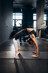 Slim athletic woman doing exercise bridge at gym