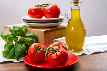 Vegetarian food - ripe red sweet tomatoes, green basil and extre virgin olive oil