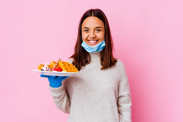Young surgeon woman holding a waffle isolated