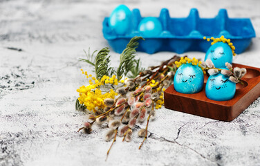 Festive background with funny Easter eggs and spring flowers on gray.  background, copy space