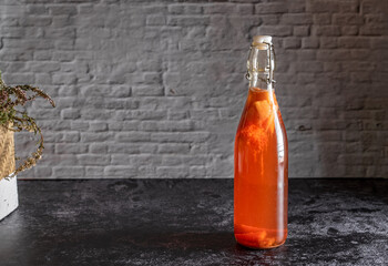 Isolated bottle of homemade kombucha, a brew fruit tea with probiotic,bacteria and yeast. Second...