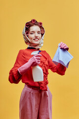 Portrait of a beautiful happy woman in the hands of a spray for washing windows and a rag. He looks at the camera. Yellow background. Pin-up style.