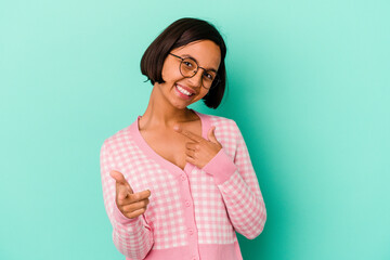 Young mixed race woman isolated on blue background cheerful smiles pointing to front.