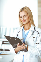 Woman-doctor controls medication history record and medical exam results. at black clipboard. Medicine concept