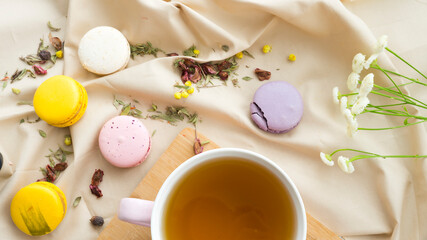 Beautiful delicate composition of a cup of green tea and multi-colored macaroon cakes