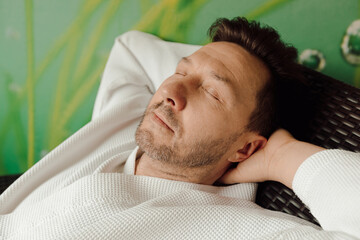 Close up portrait of handsome attractive peaceful man enjoying free time with closed eyes. spa relaxation concept