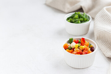 Frozen vegetables in white bowls. Horizontal orientation, copy space.