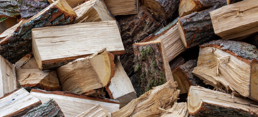 Firewood pile stacked chopped wood trunks, close-up background
