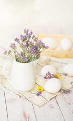 Rustic composition. Basket with white eggs and fresh flowers on wooden background. Image with selective focus